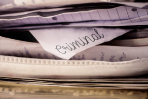 Stack of paper with a paper labeled criminal