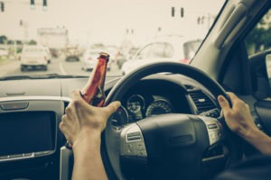 Questions to Ask a Lawyer About Your DUI Case | Simmrin Law Group a driver holding an open beer bottle while driving