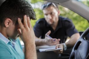 Traffic Violation Lawyer in Los Angeles, CA | Simmrin Law Group police officer writes ticket for distraught motorist