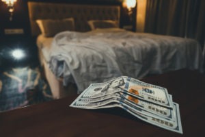 stack of money on bedside table in hotel room