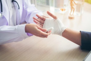 Los Angeles Burn Injury Lawyer | Simmrin Law Group | Free Consultations a doctor wrapping a burn on the hand of a patient
