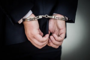 Los Angeles Embezzlement Lawyers | Simmrin Law Group businessman wears handcuffs behind back