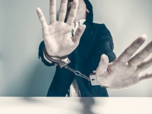 Can You Get Compensation for Being Falsely Accused of a Crime? handcuffed suspect pleading innocence