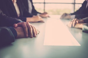 people sitting on either side of conference table