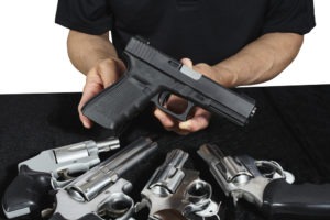 L.A. Unlicensed/ Illegal Sale of Firearms Defense Lawyers salesman shows off firearm wares