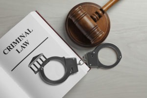 San Bernardino Criminal Defense Lawyer | Simmrin Law Group | Call 24/7 handcuffs a gavel and a book about criminal law
