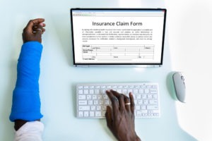 person with arm cast filling out online insurance form