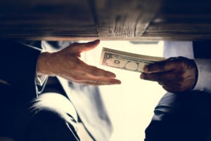 Bribery Lawyer in Downey | Free Consultations 24/7 a man handing cash to another under the table