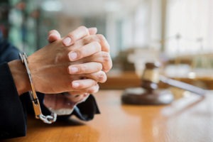 PC 1018: Motion to Withdraw a Plea in California plaintiff’s hands in handcuffs on bench