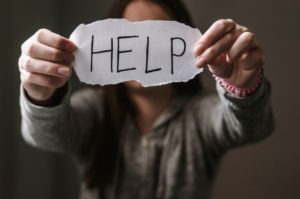 girl holding a help sign