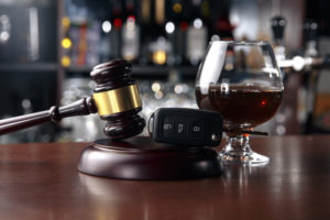 car key fob between gavel and glass of wine