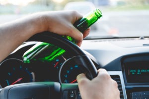 DUI Lawyer in Palmdale, CA | Free Legal Consultation pov of man holding beer bottle and steering wheel