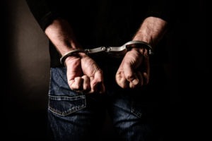 Identity Theft Lawyer in Downey | Free Consultations 24/7 man with hands cuffed behind back