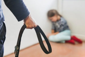 Domestic Violence Defense Lawyer in West Covina man holding a belt approaching a child