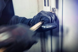 A man breaking into a door. You can learn about California Penal Code Section 459: burglary charges with our team.