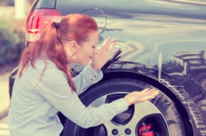 Hit-and-Run Lawyer in Ontario | Free Consultation woman inspecting hit-and-run damage