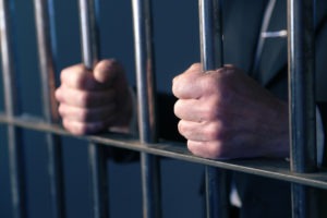 Criminal Defense Lawyer in Adams-Normandie | Free Eval white man hands behind bars