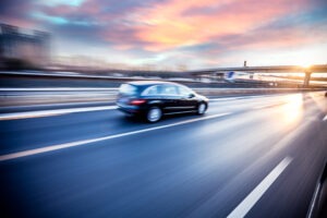Stay Safe on the Freeway With These Tips | Simmrin Law Group Black car driving on the freeway at sunset