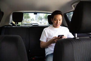 Rideshare Accident Lawyer in Costa Mesa | Free Consultations 24/7 Asian man in the back of a rideshare car