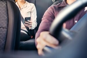 Uber Accident Lawyer in West Covina | Free Consultations 24/7 rideshare passenger using phone