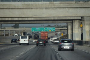 Truck Accident Lawyer in Compton | Free Consultations 24/7 Truck drives on I-105 freeway next to small cars.