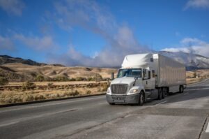 White commercial truck drives through Carlsbad.