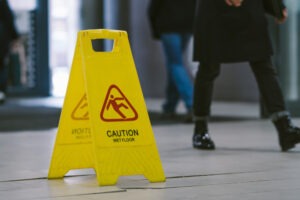 Needing a Lawyer for a Slip-and-Fall Case | Free Consultations people walking past wet floor sign