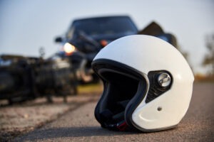 Motorcycle Accident Lawyer in Hawthorne | Free Consultations 24/7 A motorcycle helmet rests on the road after a crash. Call a Hawthorne motorcycle accident lawyer now.
