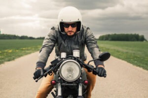 Motorcycle Accident Lawyer in Huntington Beach | Free Consultations 24/7 A motorcycle rider drives down the road. Hire a Huntington Beach motorcycle accident lawyer now.