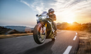 Motorcycle Accident Lawyer in Escondido | Free Consultations 24/7 Person riding motorcycle through Escondido near coast.