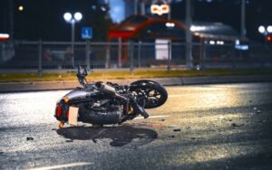 Motorcycle Accident Lawyer in Redondo Beach | Free Consultations 24/7 a damaged motorcycle lying on the asphalt at night