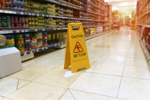 Slip and Fall Accident Lawyer in Covina | Free Consultations 24/7 a grocery store aisle with a yellow wet floor sign