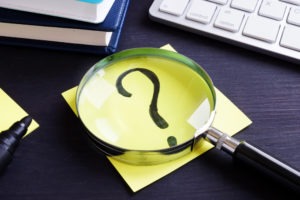 What Is the California Castle Doctrine (Stand Your Ground)? Magnifying glass on top of a piece of paper as someone nearby is learning about what is California’s Castle Doctrine