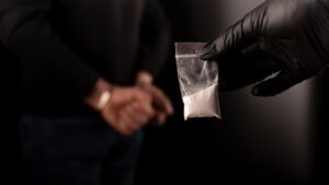 Felony vs. Misdemeanor Drug Possession in California A man is handcuffed while another holds up a substance in a bag. In California, drug possession is usually charged as a misdemeanor in California, but it can be a felony in some cases.
