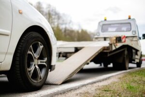 California VC §22651: California Impound & Towing Laws A white car is being loaded onto a tow truck. Learn about California Vehicle Code §22651: California Impound & Towing Laws here.