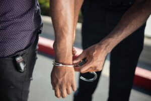 A police officer putting handcuffs on a man, with respect to the search and seizure laws of California.