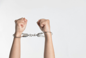 A person with handcuffs on their hands.